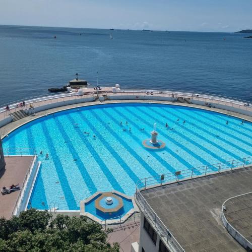 a large swimming pool next to the water at Primrose Cottage in Plymouth
