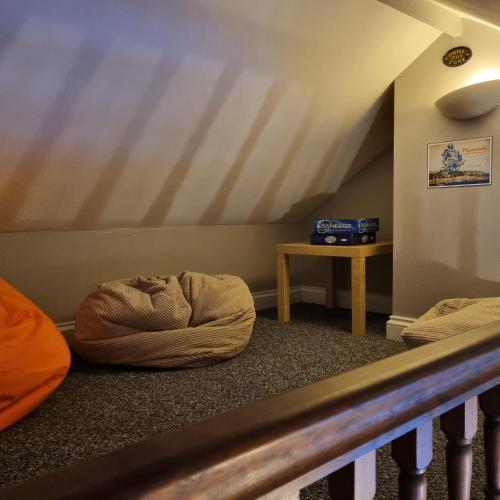 a room with two bean bags on the floor and a table at Primrose Cottage in Plymouth
