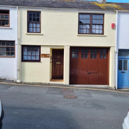 a house with two garage doors on a street at Primrose Cottage in Plymouth
