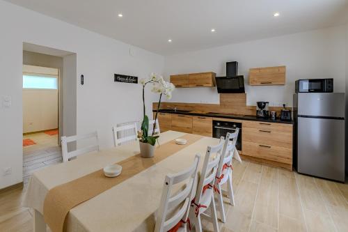 une cuisine et une salle à manger avec une table et un réfrigérateur dans l'établissement La Maissemiacoise - Belle Maison de campagne, à Maissemy