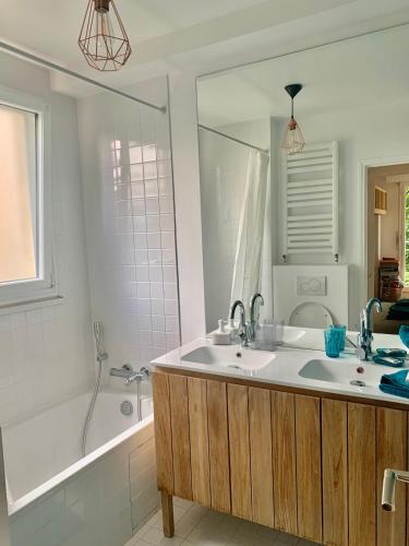 une salle de bain avec un lavabo, une baignoire et une douche dans l'établissement Appartement rénové en bordure de forêt, à Clamart
