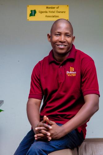 a man in a red shirt sitting on a couch at Belmont Villas Mbale in Mbale