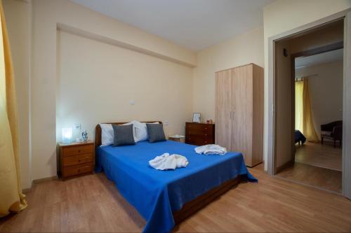 a bedroom with a blue bed with towels on it at Villa Angelique in Sinarádes