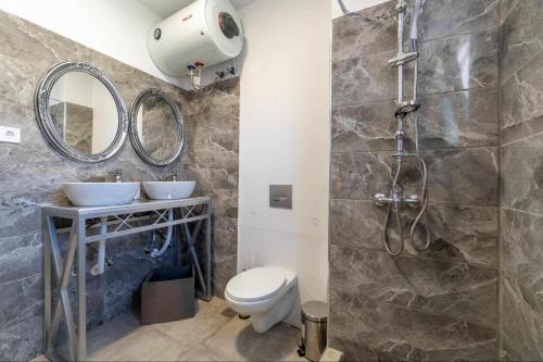 a bathroom with a shower and a toilet and a sink at Villa Angelique in Sinarádes
