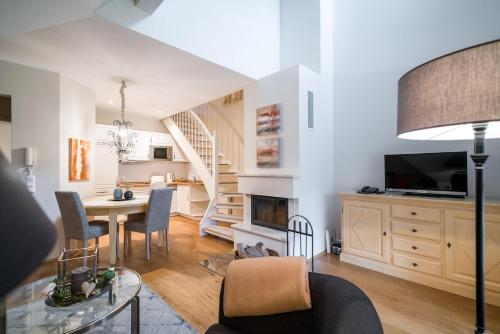 a living room with a dining room table and a staircase at Apartmenthaus Haus Sonne I direkt am Strand in Dierhagen