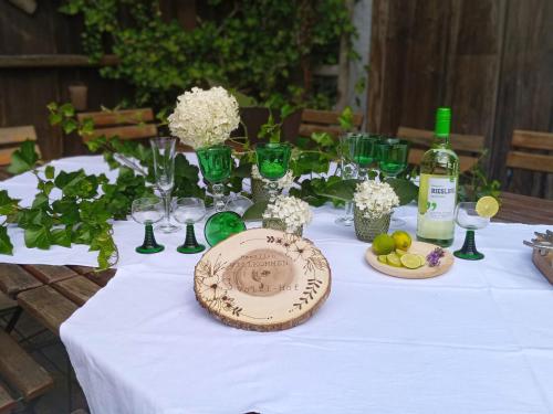 a table with a white table cloth and a bottle of wine at Völtl-Hof in Büchlberg