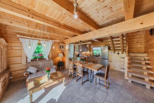 a dining room and kitchen in a log cabin at Leśny Zakątek Jurków in Jurków