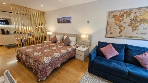 a bedroom with a bed and a blue couch at Cantinho do Auka - Studio in Aveiro