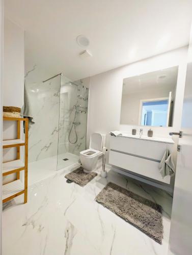 a white bathroom with a sink and a toilet at Seaview wonder apartment by Anna in Funchal