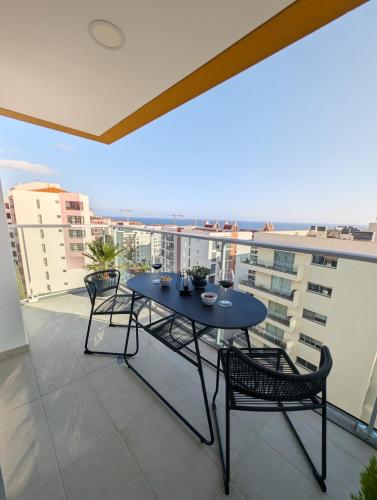 a table and chairs on a balcony with a view at Seaview wonder apartment by Anna in Funchal