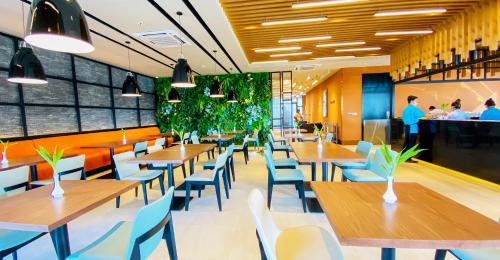 a restaurant with wooden tables and blue chairs at Siha Treasure Hotel in Sihanoukville