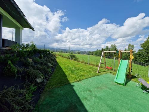 a playground with a swing in a yard at Chałpy Na Wierchu in Rzepiska