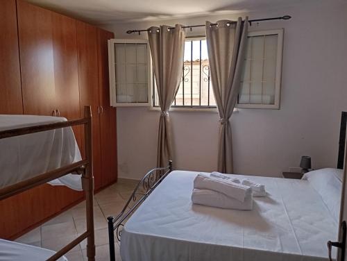 Un dormitorio con una cama con dos toallas blancas encima. en Casa vacanze da viola, en Ugento