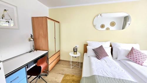 a bedroom with a bed and a desk and a mirror at "Casa Antonio" 3 Gehminuten Strandbad Sekirn, inkl Seezugang in Sekirn