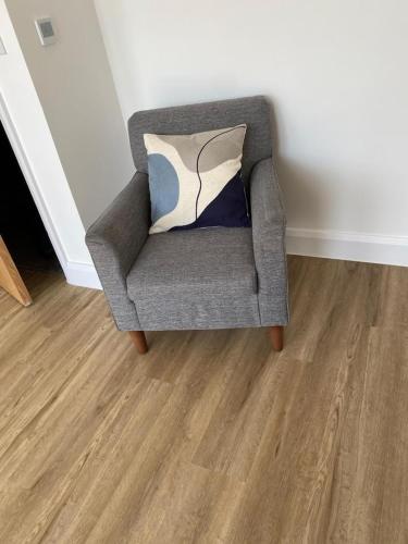 a gray chair with a pillow in a room at Beach Front in Clacton-on-Sea