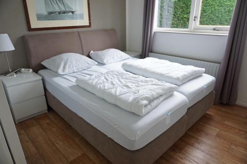 a bed with two pillows on it in a bedroom at Kustverhuur, Vakantiepark Fort Soleil 60 in Breskens