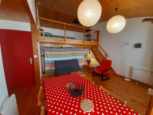une chambre avec une table rouge et un lit à pois rouges et blancs dans l'établissement Studio 38m2 pour un séjour tout confort et au calme en hyper centre, à Rochefort