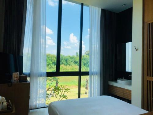 Ένα ή περισσότερα κρεβάτια σε δωμάτιο στο Zensala Riverpark Resort-SHA Extra Plus