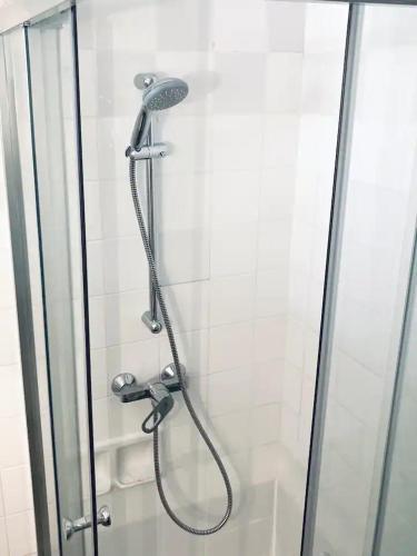 une douche avec pommeau de douche dans une salle de bain dans l'établissement Chambre avec balcon dans une appartement la belle de mai, à Marseille