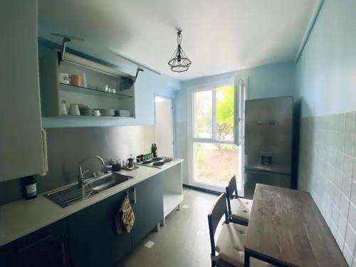 une cuisine bleue avec une table en bois et un évier dans l'établissement Chambre avec balcon dans une appartement la belle de mai, à Marseille