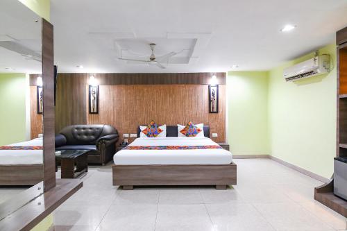 a hotel room with two beds and a television at FabHotel Raj Residency II in Rānchī