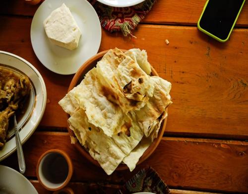 a plate of food on a wooden table with food at BenSon Adventures Resort in Gomkʼ