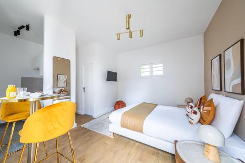 une chambre avec un lit, un bureau et des chaises dans l'établissement Studio proche Paris Expo Porte de Versailles, à Issy-les-Moulineaux