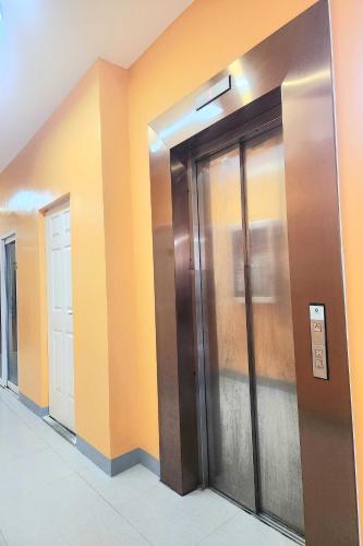 a row of elevator doors in a building at Qingqing Hotel Pasay Manila near MOA in Manila