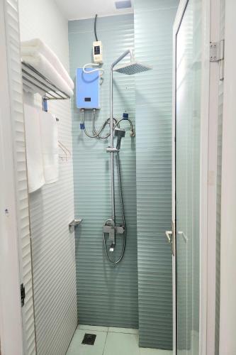 a shower in a bathroom with a glass door at Qingqing Hotel Pasay Manila near MOA in Manila