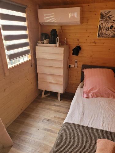 une petite chambre avec un lit et une fenêtre dans l'établissement Loue chalet de 11m2, à Auribeau-sur-Siagne