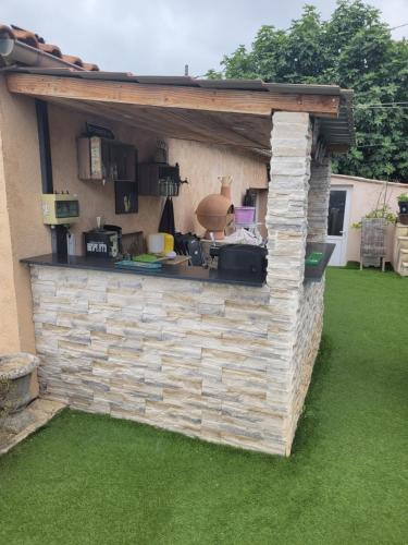 une cuisine extérieure avec un mur en briques dans l'établissement Loue chalet de 11m2, à Auribeau-sur-Siagne