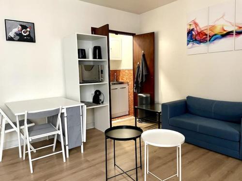 un salon avec un canapé bleu et une cuisine dans l'établissement Anthony's Residence, à Paris