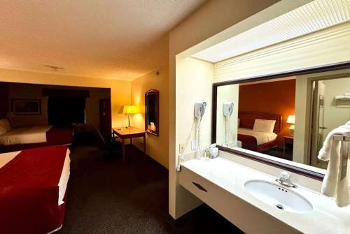 a hotel room with a bathroom with a sink and a mirror at Baymont by Wyndham Mason in Mason