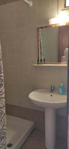 a bathroom with a sink and a mirror and a tub at Kiparissis Apartments in Kriopigi