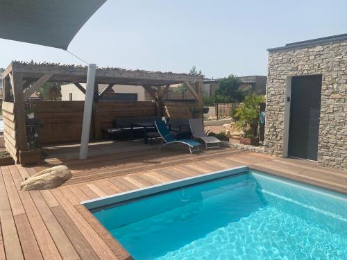 - une piscine sur une terrasse en bois avec une pergola dans l'établissement Villa standing Arciquadra Porto Vecchio, à Lecci