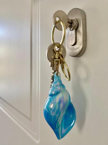 a key chain with a blue glass bottle on a door at Casa Chicchella- Authentic Experience in Vieste