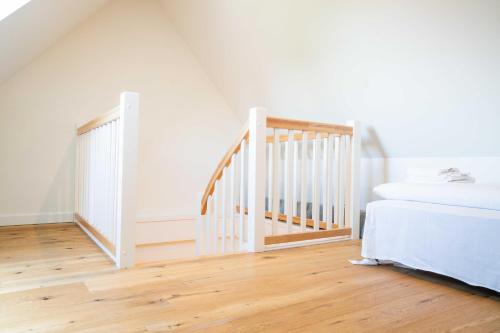 a bedroom with a staircase and a bed at Traumgarten Haus Unschuld in Prerow