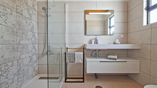a bathroom with a sink and a glass shower at Casa Vitória - with private pool in Pêra