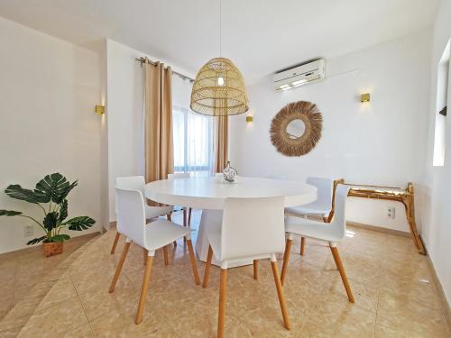 a white dining room with a white table and chairs at Casa Vitória - with private pool in Pêra