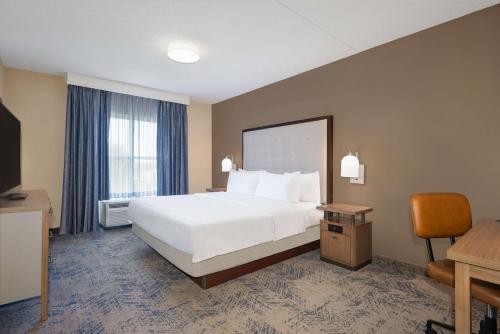 a large hotel room with a bed and a desk at Homewood Suites Fredericksburg in Fredericksburg