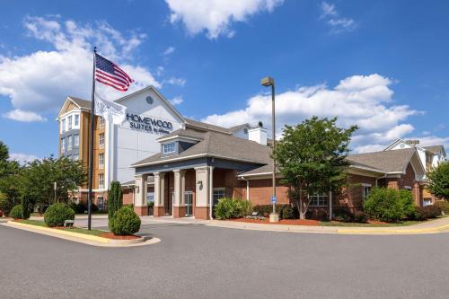 a hotel with an american flag in front of it at Homewood Suites Fredericksburg in Fredericksburg
