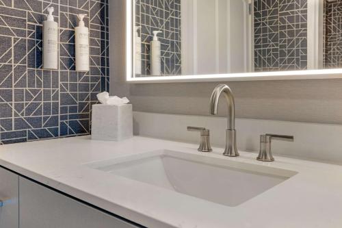 a bathroom with a white sink and a mirror at Homewood Suites Fredericksburg in Fredericksburg