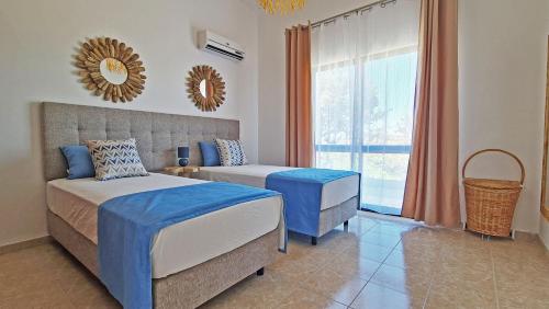 a bedroom with two beds and a window at Casa Vitória - with private pool in Pêra