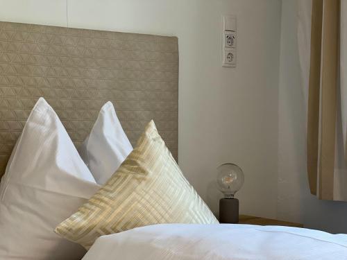 a bed with white pillows and a head board at Apartments Salzburg - Bergstraße in Salzburg