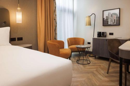 a hotel room with a bed and a table and chairs at DoubleTree by Hilton London Victoria in London