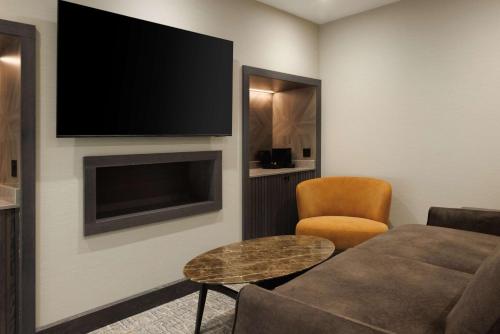 a living room with a couch and a flat screen tv at DoubleTree by Hilton London Victoria in London
