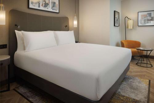 a large white bed in a hotel room at DoubleTree by Hilton London Victoria in London