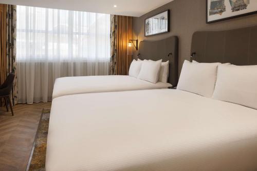 a hotel room with two beds and a window at DoubleTree by Hilton London Victoria in London