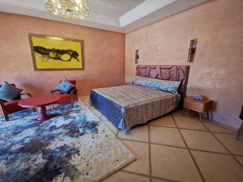 a bedroom with a bed and a table in it at Domaine Lamrah in Marrakesh