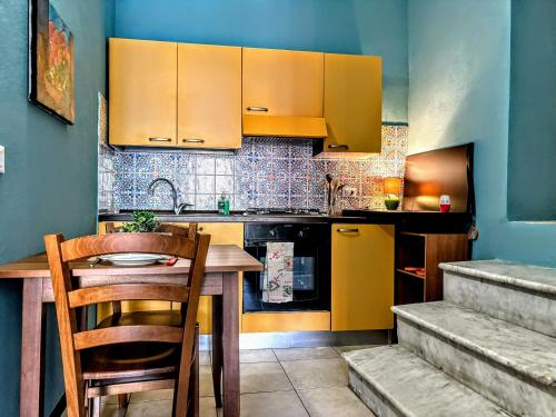 a kitchen with a wooden table and yellow cabinets at Antica Dimora - Appartamento 6 in Bosa